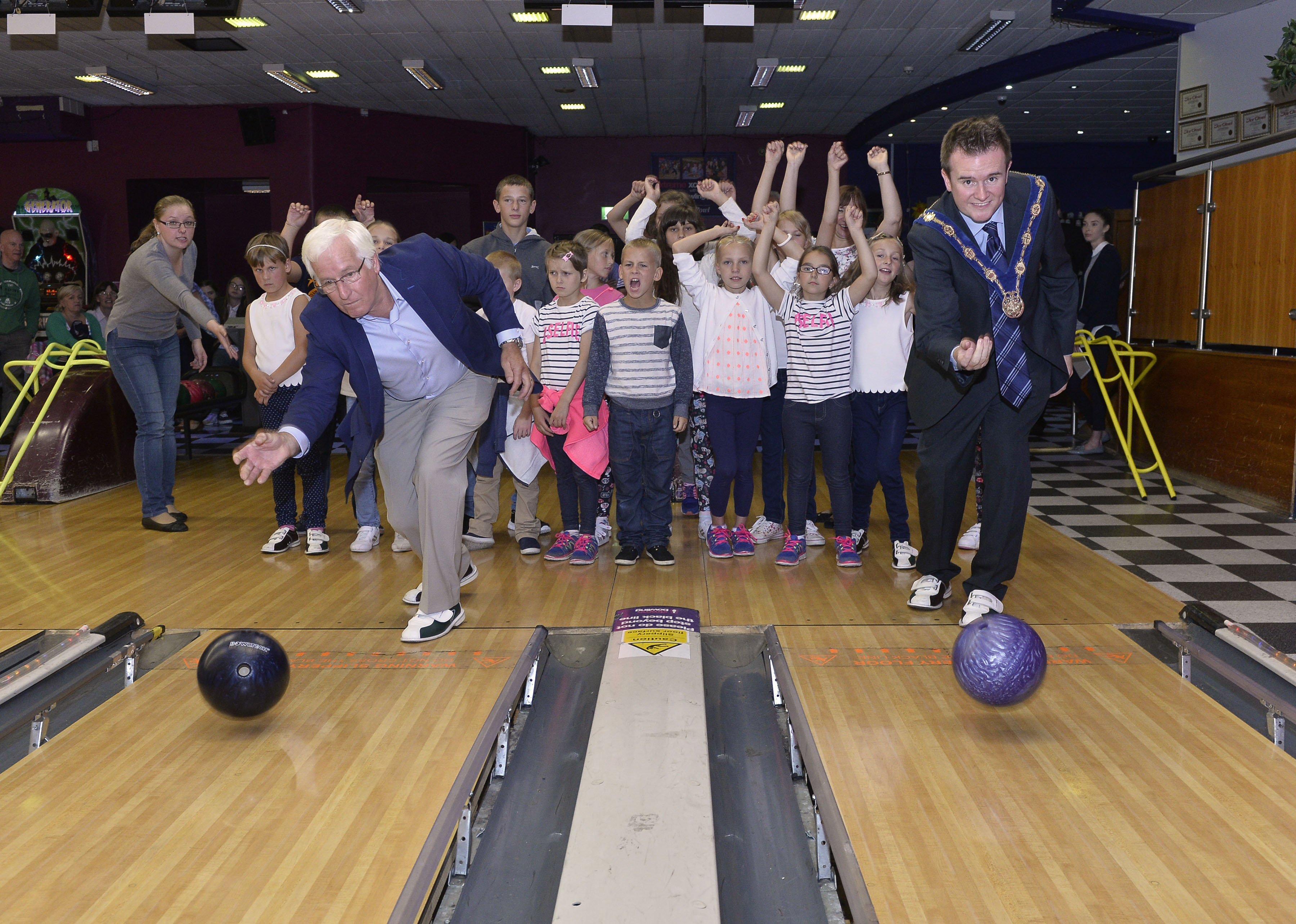 Deputy Mayor of Lisburn & Castlereagh City Council, Alderman Stephen Martin and Vice Chairman of Leisure & Community Services, Councillor Alan Givan join the children from Belarus on the lanes at Dundonald International 